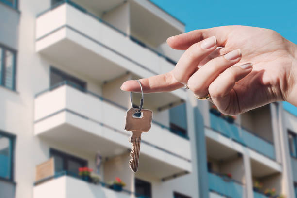 Hand holding keys in front of a modern apartment – increase property value before selling in Barcelona